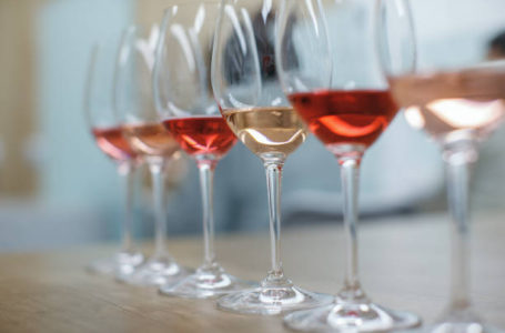 Row of glasses with white and rose wines prepared for tasting